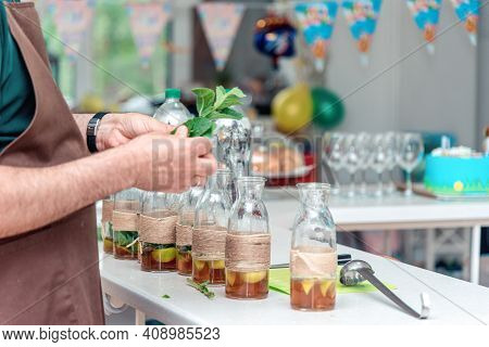 Male Bartender Hands Holding Mint Herb, Preparing Summer Refreshing Lemonade Drink For Big Friendly 