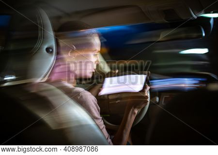 Young female driver playing with her cellphone instead of paying attention to driving startled in a potentially dangerous situation - Road safety concept