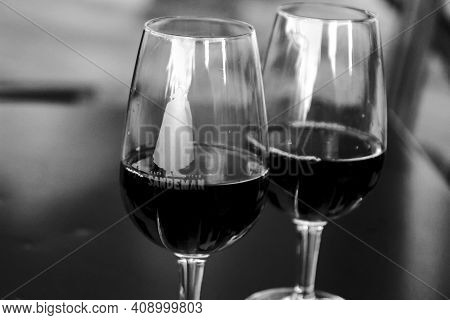 Porto, Portugal- December 30, 2019: Two Glasses Of Tasty Port Wine Tawny Sandeman Brand On A Table I