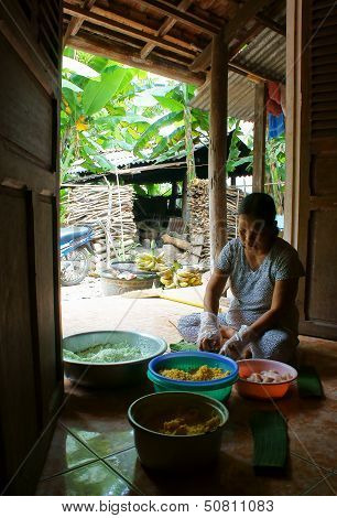People make  Cylindric glutinous rice cake (banh tet) for Tet