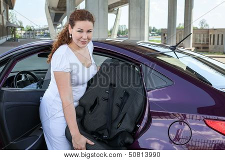 Mother Installing Child Restraint Seat In The Car