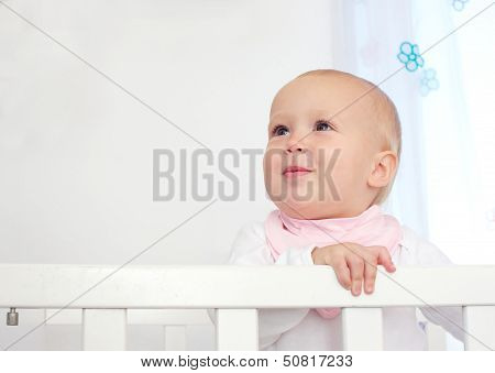 Portrait Of An Adorable Baby Standing In Crib