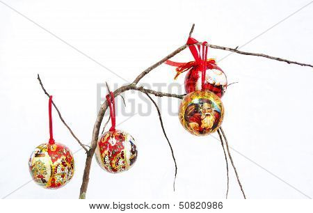 Three Red Christmas Decorations On A Dry Branch