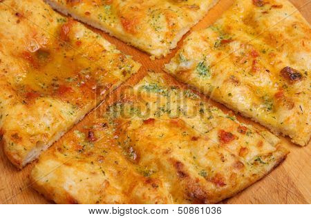 Garlic pizza bread with sunblush tomatoes and herbs.