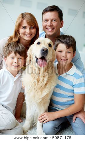 Portrait of happy family with their pet looking at camera