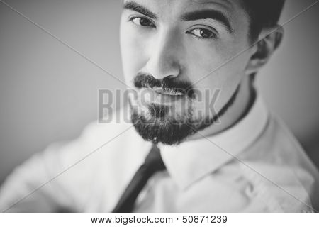Black-and-white image of posh guy looking at camera
