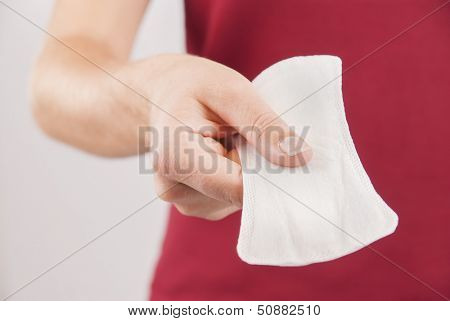Young woman wearing red t-shirt holding mentrual pad