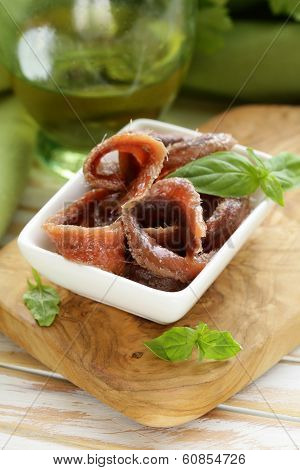 Canned marinated anchovies fillets in a white bowl