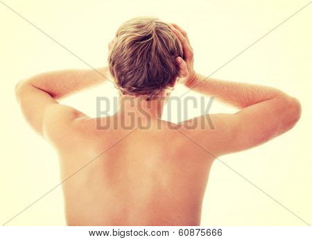 A young man grasping his head where the pain is - a killer headache or migraine. 