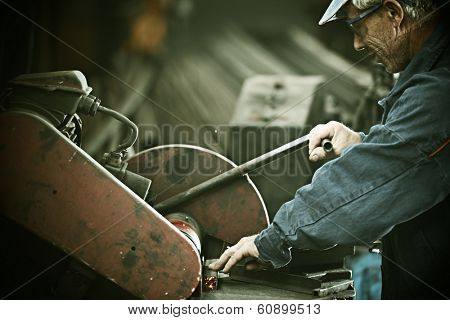 Industrial worker cutting and welding metal with many sharp sparks
