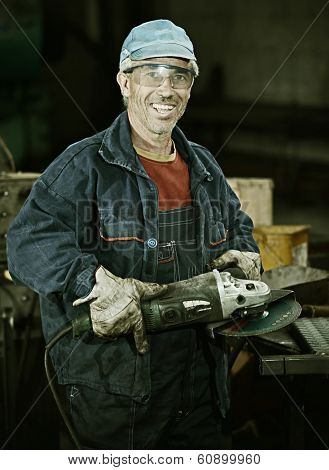 Industrial worker cutting and welding metal with many sharp sparks