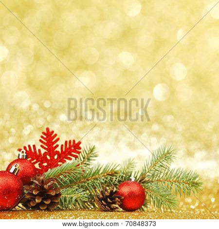 Christmas card with fir branch and decorations on golden gitter background