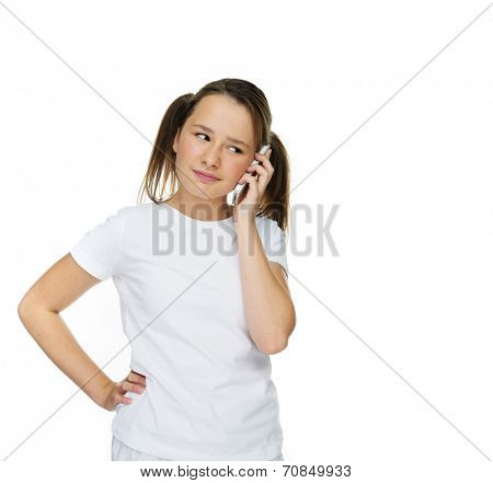 Young girl with a puzzled expression chatting on her mobile pone looking dubious about what is being said, isolated on white