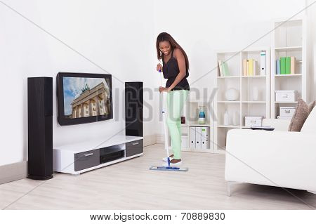 African American Woman Cleaning Floor In Living Room