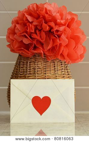 Vase basket with pom pom red tissue paper flower and a love letter