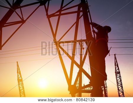 Worker At An Electric Substation With Sunset Background