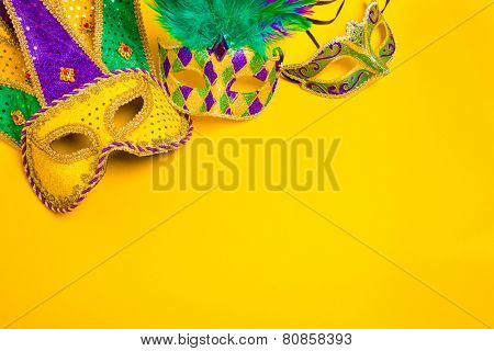 Assorted colorful Mardi Gras mask on yellow background