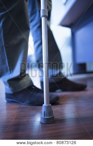 Man Walking With Crutches In Hospital Clinic