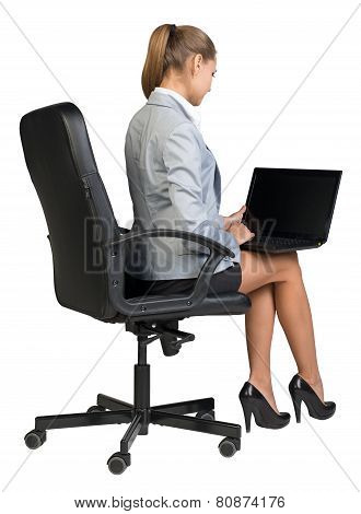 Businesswoman on office chair, with laptop