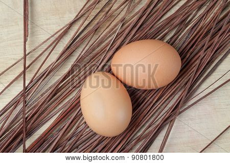 Two eggs resting on wooden chopping board