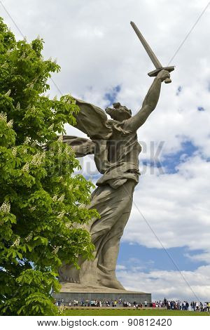 The Sculpture Of The Motherland Is Calling Mamayev Kurgan On The Background Of A Flowering Chestnut