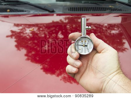 A Mechanic Checking Tire Pressure With A Tire Guage