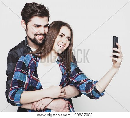 tehnology, internet, emotional  and people concept: Capturing happy moments together. Happy young loving couple making selfie and smiling.Special Fashionable toning. 