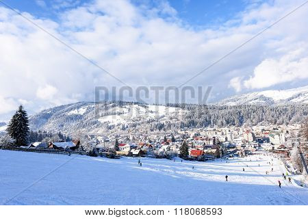 VATRA DORNEI, ROMANIA - FEBRUARY 2016: Ski slope with happy people at mountains with blue sky