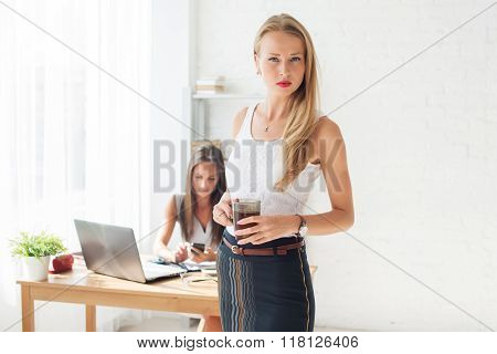 Portait of beautiful successful business woman holding cup coffee looking confident and serious