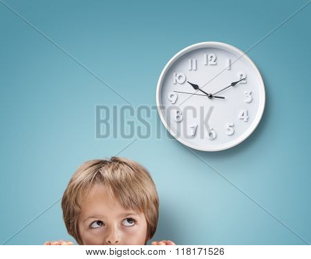 Young boy looking up at a clock concept for deadline, anxiety and stress