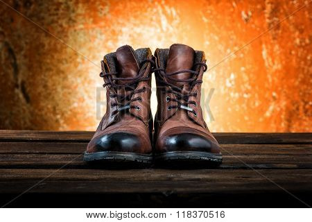 Men's brown winter boots isolated on rusty wooden background