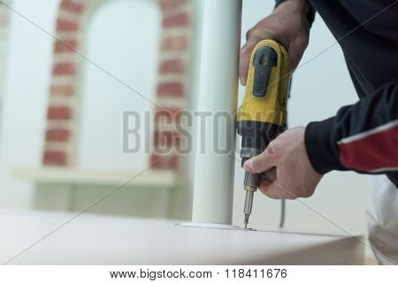 repairman working with drilling machine and assambling  furniture