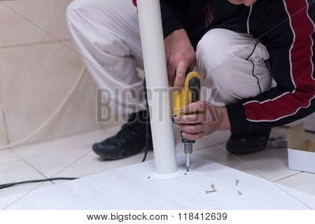 repairman working with drilling machine and assambling  furniture
