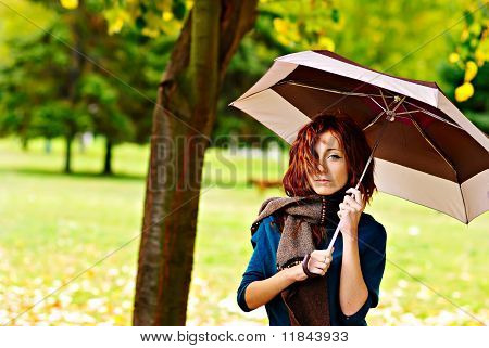 Donna è in possesso di ombrello nella foresta di autunno