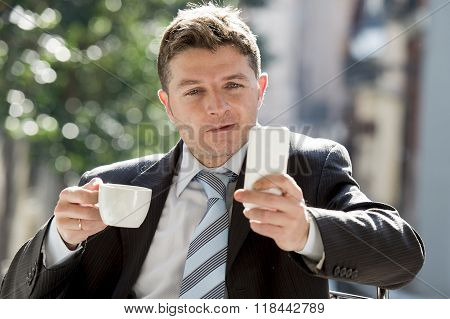 Attractive Businessman Sitting Outdoors In Coffee Break Using Mobile Phone Checking Onl¡ne News