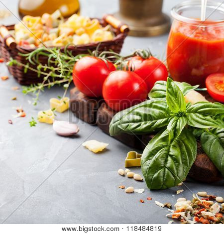 Italian food background with vine tomatoes, basil, spaghetti, olives Ingredients on stone table Copy