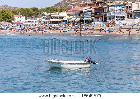 MATALA, GRETE - AUGUST 20, 2013: View on white motor boat and people at Matala beach, located on Crete island, Greece