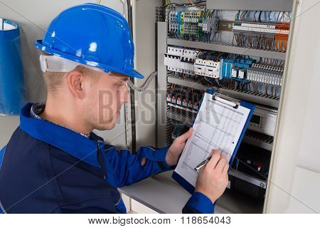 Young Male Technician Examining Fusebox