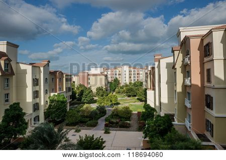 A cluster of buildings with green landscaping in a residential community from Dubai.