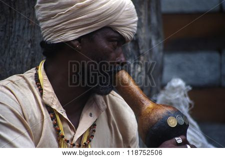 VASHISHT, INDIA - JULY 5, 2006 - A snake charmer draws a crowd with his cobras in baskets in Uttar Pradesh.