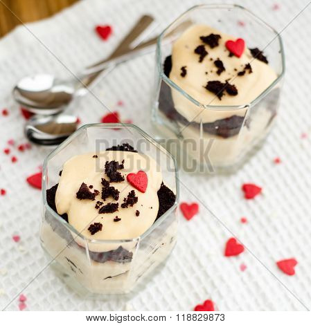 Chokolate desserts in glasses with hearts and spoons