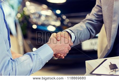 auto business, car sale, deal, gesture and people concept - close up of male handshake in auto show or salon