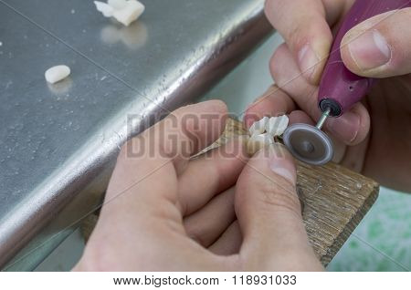 Technician With Tooth Made In Lithium Disilicate With Diamond Discs.