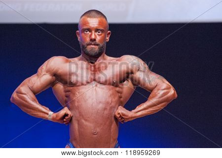 Male Bodybuilder Flexes His Muscles To Show His Physique