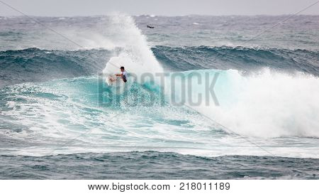 SUNSET BEACH HAWAII USA - DECEMBER 2, 2017: Surfer competing at the 2017 Vans World Cup of Surfing competition at Sunset Beach on Oahu's scenic North Shore. This is the second of three surfing competitions and Conner Coffin took first place.