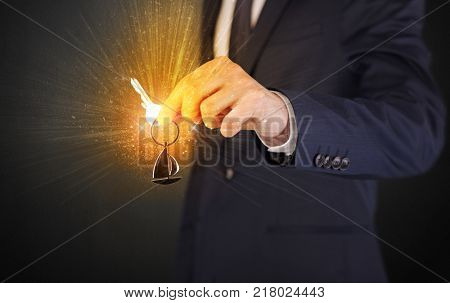 Formal man hand over shiny keys with dark background