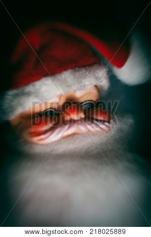 Macro close up portrait of a vintage 1950s creepy Santa Claus with a retro filter and dramatic lighting