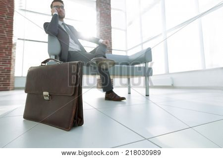 businessman holding his briefcase in office