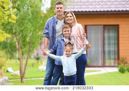 Happy family in courtyard near their house