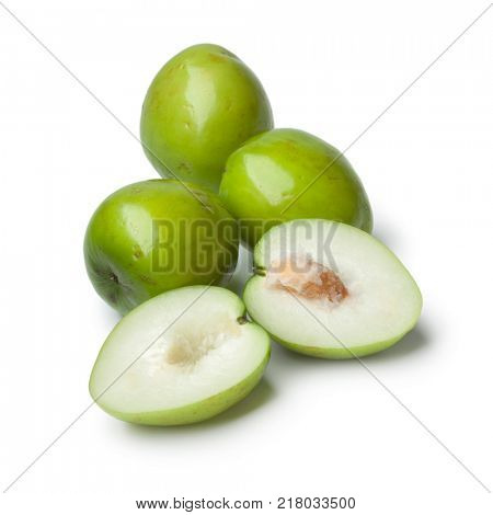 Fresh green whole and half Ambarella fruit with a fibrous pit on white background